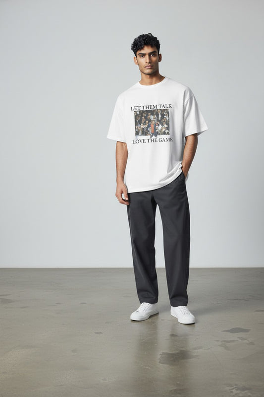 FussballVibe white cotton unisex t-shirt with "Let Them Talk Love The Game" graphic featuring a footballer celebrating.