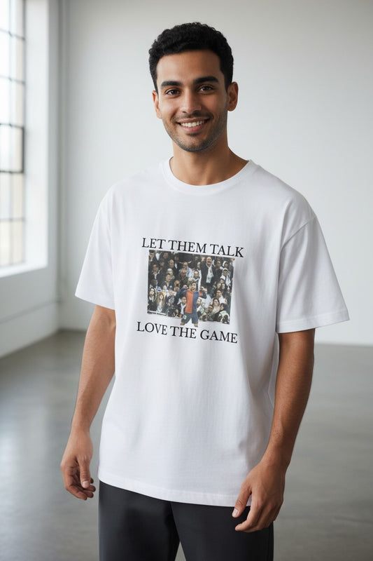 FussballVibe white organic cotton oversized t-shirt with "Let Them Talk Love The Game" graphic print.